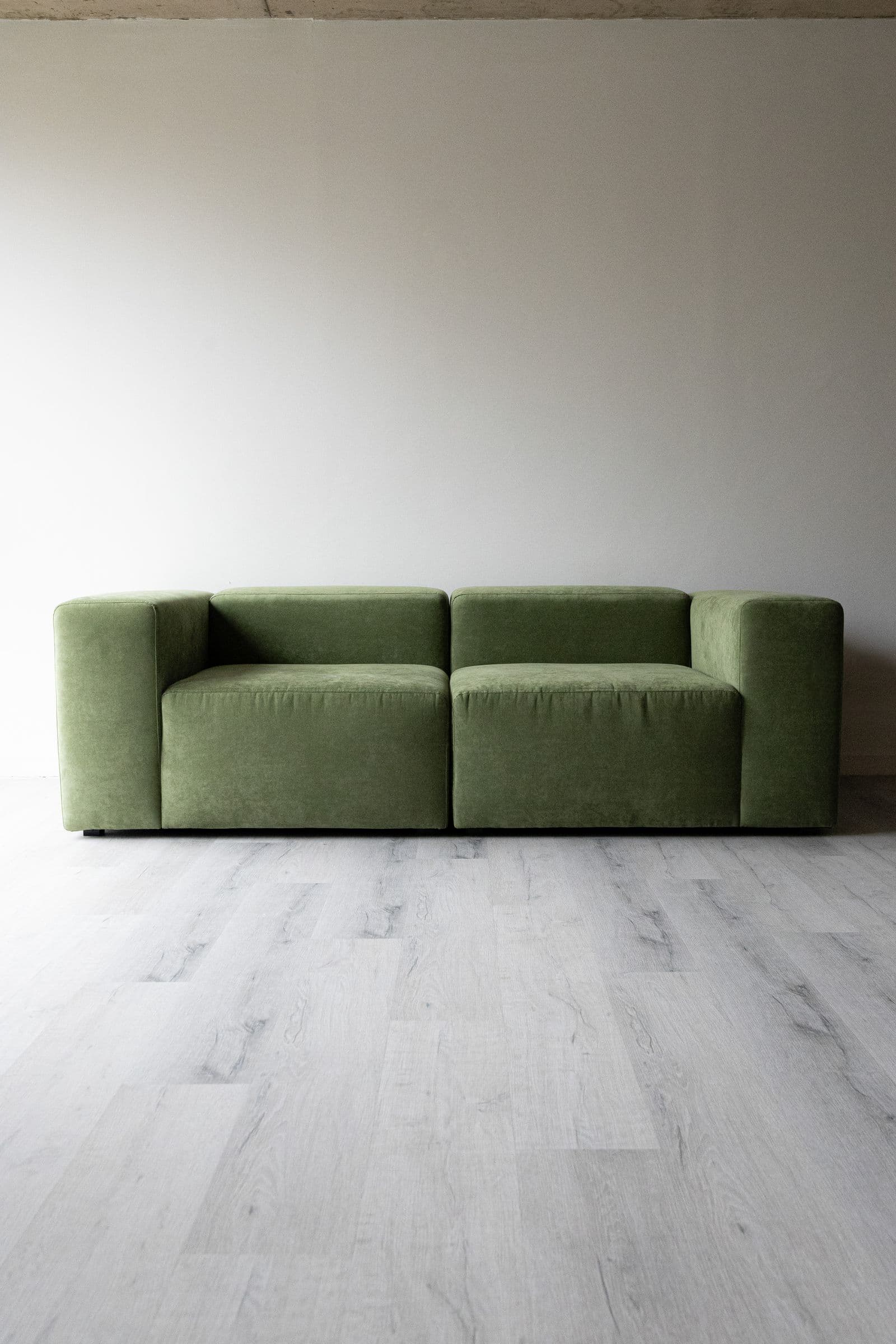 Ébano — Sofá modular en pana verde oliva, tacto aterciopelado mate.