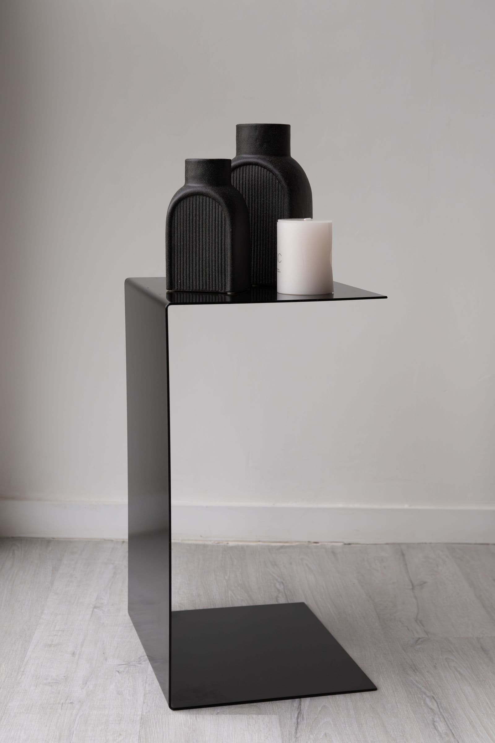 Sidney — Mesa auxiliar en forma de C de hierro negro mate, silueta monolítica.